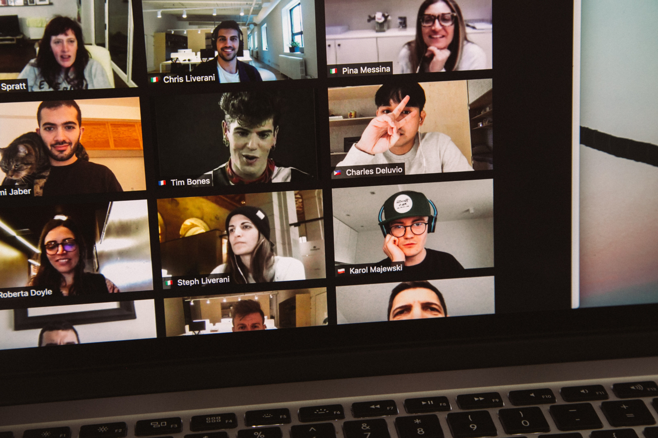 A business video conference on a laptop screen with twelve active participants