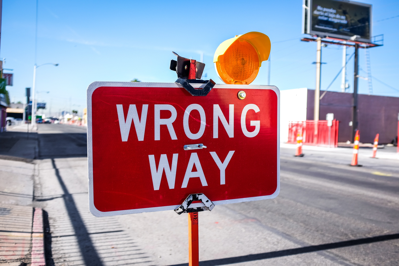 A red and white road sign reading wrong way